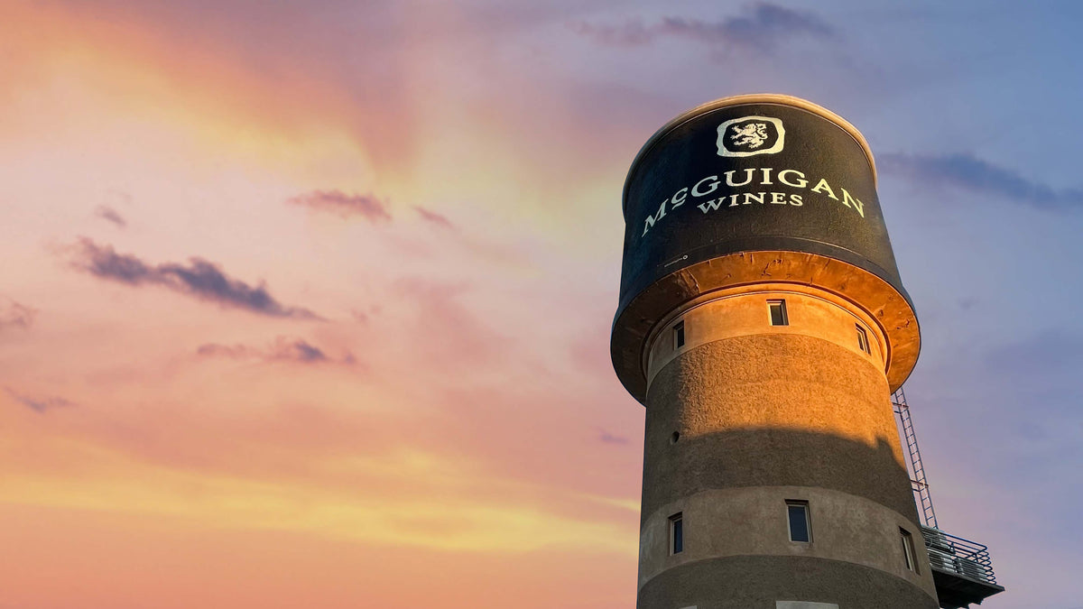 Water tower with McGuigan Wines branding against a colorful sky